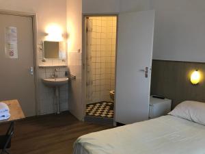 y baño con cama, lavabo y ducha. en hotel Oosterpark, en Ámsterdam