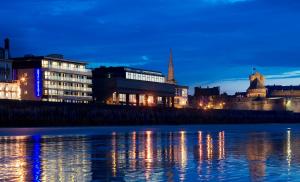 a city skyline at night with a river and buildings at Oceania Saint Malo in Saint Malo