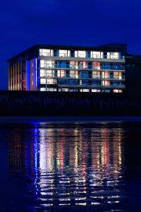 a building lit up at night next to the water at Oceania Saint Malo in Saint Malo