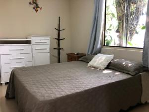 um quarto com uma cama e uma janela grande em Pousada Ondas de Floripa em Florianópolis mais 37 fotografias