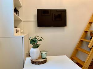 a white vase sitting on a table with a plant at Charming Studio in Krakow