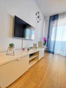 a living room with a tv on a white wall at Tusculum apartment Solin in Solin