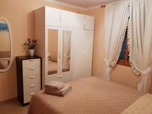 アデへにあるBuganvillasのベッドルーム1室(ベッド1台、ドレッサー、鏡付)