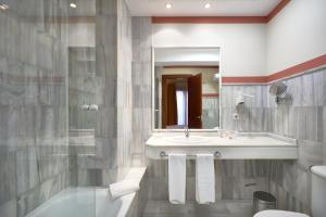 a bathroom with a sink and a toilet and a mirror at Hotel Murillo in Seville