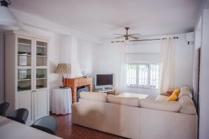 a living room with a white couch and a television at Casa Atlantis in Chipiona