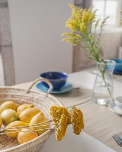 una mesa con una cesta de pan y un jarrón con flores en Own Places Clérigos Apartments, en Oporto