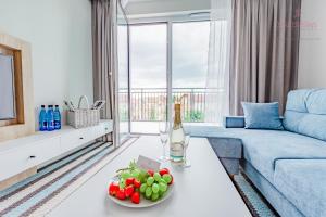 a living room with a blue couch and a table with fruit at Your Holidays Bel Mare II in Międzyzdroje