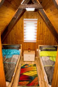 een slaapkamer met 2 bedden in een houten hut bij Napsugár Vendégház Bükkszentkereszt in Bükkszentkereszt