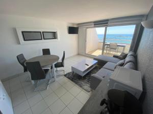 ein Wohnzimmer mit Sofa und Tisch in der Unterkunft Loriot2 - appartement vue sur mer in Ploemeur