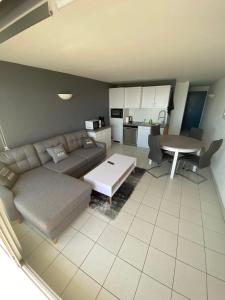 ein Wohnzimmer mit Sofa und Tisch in der Unterkunft Loriot2 - appartement vue sur mer in Ploemeur