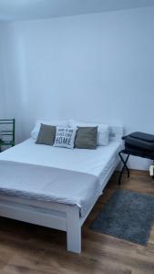 a white bed with a pillow with a sign on it at Casa Maia Kosmaj in Dučina
