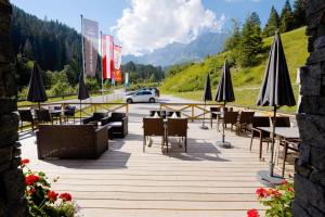 ein Restaurant mit Tischen und Sonnenschirmen auf einer Straße in der Unterkunft Hotel-Restaurant Bike&Snow Lederer in Mühlbach am Hochkönig