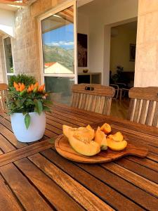 a plate of sliced fruit on a wooden table at City apartments Bobic in Cavtat