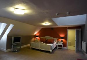 a bedroom with a bed and a tv in a room at Colwick Hall Hotel in Nottingham