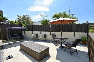 eine Terrasse mit einem Tisch, Stühlen und einem Sonnenschirm in der Unterkunft Nago - House - Vacation STAY 88505 in Nago