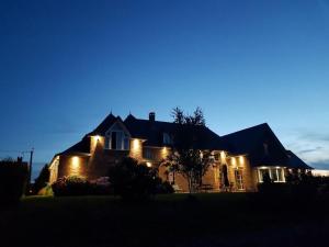 ein nachts beleuchtetes Haus mit Licht in der Unterkunft LA CHARMERAIE in Arrest