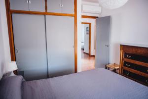 チピオナにあるCasa Atlantisのベッドルーム(青いベッド1台、ドレッサー、鏡付)