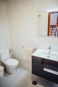 łazienka z toaletą, umywalką i lustrem w obiekcie Casa Cordoba w mieście Chipiona +17 zdjęć