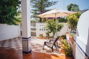 taras ze stołem i parasolem w obiekcie Casa Cordoba w mieście Chipiona