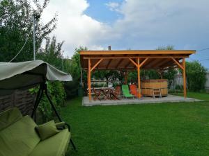 einen Pavillon mit einem Tisch und Stühlen im Hof in der Unterkunft Apollo Vendégház in Edelény