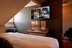 a hotel room with a bed and a tv on the wall at Bike & Boot Inns Scarborough - Leisure Hotels for Now in Scarborough