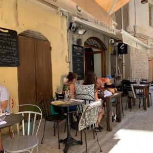 un grupo de personas sentadas en mesas en un restaurante en CASA CITADELLA Bonifacio en Bonifacio