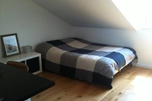 een slaapkamer met een bed en een tafel in een kamer bij Proche mer, plage et commerces à 500m in La Bernerie-en-Retz