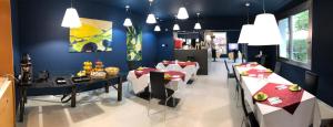 a dining room with tables and chairs and a blue wall at Villa Regina in Riva del Garda