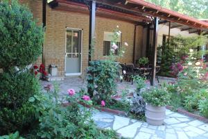 a garden with flowers and plants in front of a house at Germanos Studios in Kato Loutraki