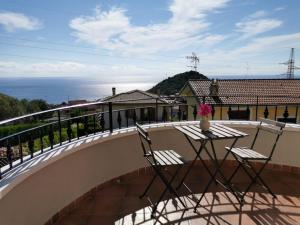 a balcony with two chairs and a table with a vase on it at La Terrazza degli Dei in Buonvicino +43 photos
