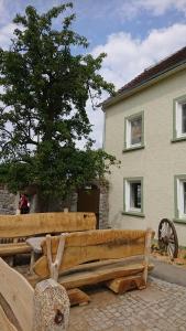 un banco de madera sentado frente a una casa en Urlaub auf dem Bauernhof,Landurlaub,Ferienwohnung, en Gränze