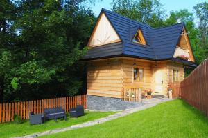 a log cabin with a black roof at Domek Pod Ubocom in Zakopane