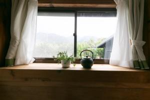 Kumage-gun - House - Vacation STAY 89468 في Yudomari: نافذة بها نبات على حافة نافذة خشبية