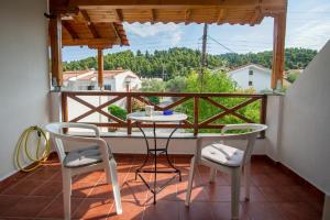 a balcony with a table and two chairs and a window at Casa Costa for 7 guests near Fourka beach in Skala Fourkas