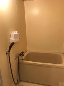 eine Badewanne im Bad mit einer Lampe daneben in der Unterkunft It's Town Kasuga B Building - Vacation STAY 89474 in Kasugabaru
