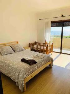 sypialnia z łóżkiem i dużym oknem w obiekcie Carminho beach house w mieście Vila do Conde