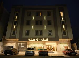 a building with cars parked in front of it at night at Sela Hotel فندق صلة in Medina