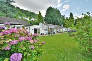 a row of houses with flowers in the yard at The Paddocks Cottages in Symonds Yat