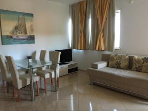 ein Wohnzimmer mit einer Couch, einem Tisch und einem Fernseher in der Unterkunft Apartments Sanja in Hvar