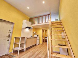 a kitchen with yellow walls and a wooden ladder at Kunigami-gun - Hotel - Vacation STAY 89678 in Inbu