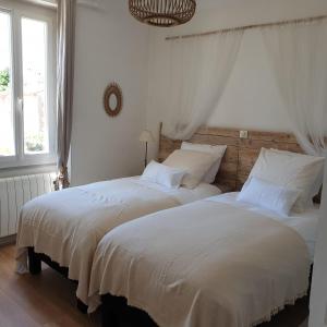 2 letti in una camera da letto con lenzuola bianche di Ocra Pure a Roussillon
