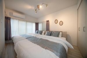 a bedroom with two large beds and a window at Grace Yotsugi - Vacation STAY 89021 in Tokyo