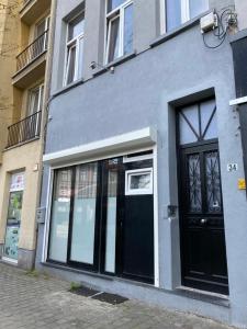 een grijs gebouw met een zwarte deur op een straat bij Sint-Jans Appartments in Antwerpen