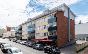a brick building with cars parked in a parking lot at City Apartment Snellmaninkatu 22 A, yksityinen pistokkeellinen paikoitus sisältyy hintaan in Kuopio +20 photos