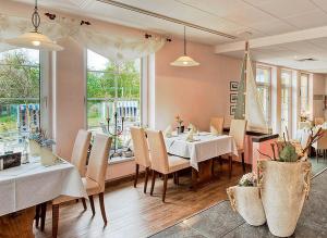 a dining room with a table and chairs and a window at Seehotel Düne in Graal-Müritz