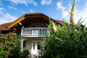 a white house with a porch and a balcony at Rooms Ambrožič in Bled