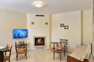 a living room with a fireplace with a tv on the wall at Villa Stylianna in Gavalochori