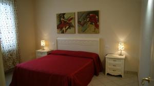 a bedroom with a red bed and two night stands at Case Vacanza La Dolce Vita in Saturnia +8 photos
