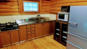 a kitchen with a stainless steel refrigerator and a microwave at Maniwa - Cottage - Vacation STAY 90022 in Maniwa