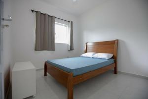 a small bedroom with a bed with a window at Recanto do Camargo in Ubatuba